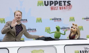 El cineasta británico James Robin y las marionetas de de Jim Henson, la rana Gustavo y Peggy la cerdita, durante la presentación de la película "Muppets, los más buscados" en el Centro Sony de Berlín (Alemania) hoy, viernes 28 de marzo de 2014. La película se estrenará en Europa el próximo 1 de mayo. EFE